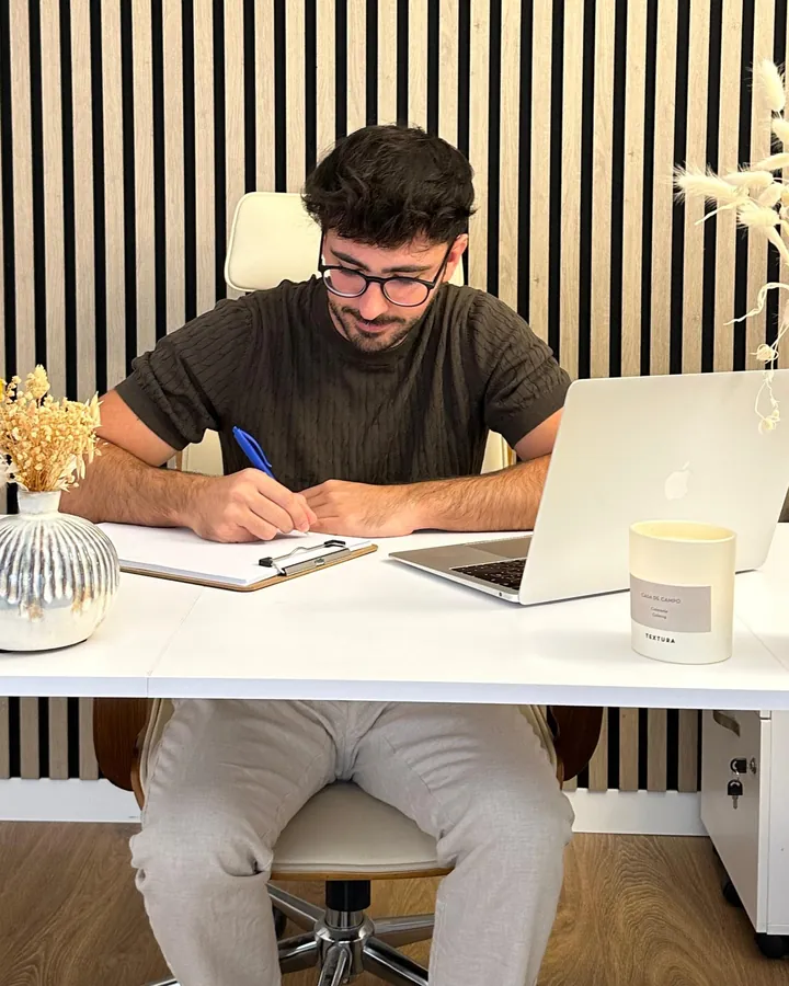 Rubén Lillo escribe en una carpeta de notas sentado a su escritorio