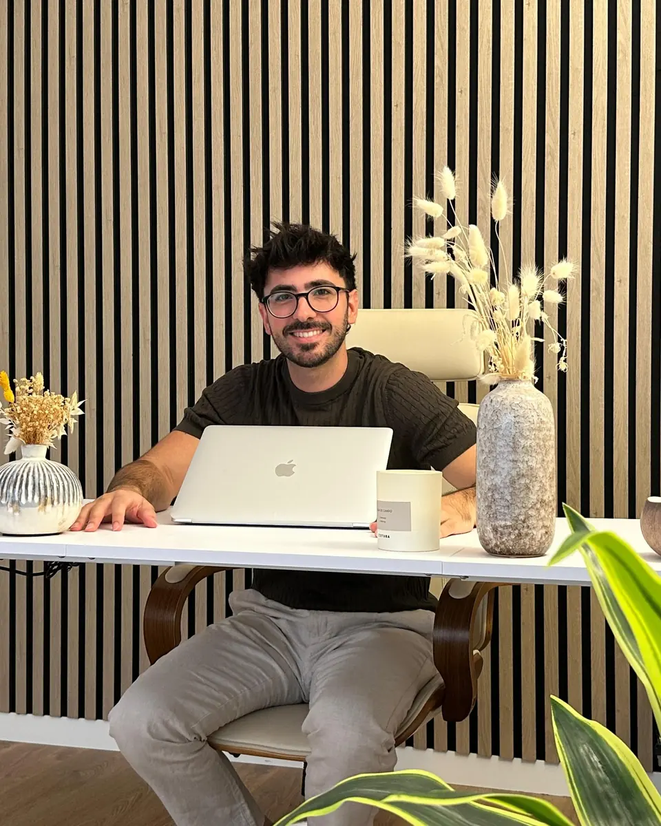 Rubén Lillo, psicólogo y sexólogo, sonríe sentado a su escritorio entre plantas